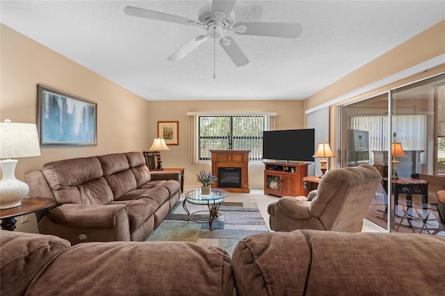 2756 Clubhouse Dr Unit 101, Sarasota, FL 34232 - living area with a glass covered fireplace, a textured ceiling, and a ceiling fan