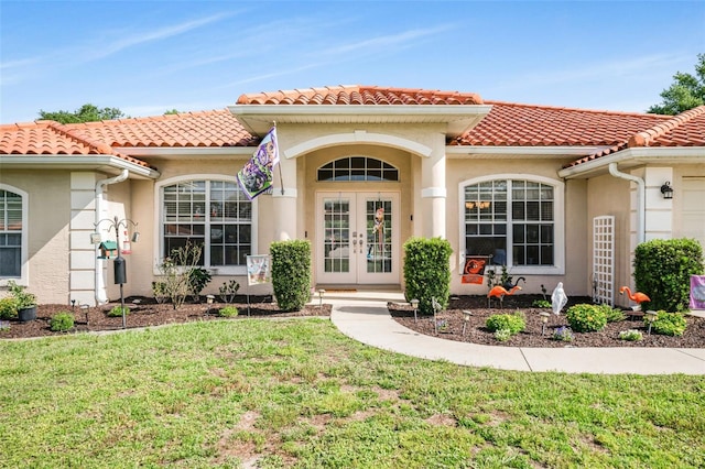 4277 E Bennett St, Inverness, FL 34453 - entrance to property with french doors, a tiled roof, a lawn, and stucco siding