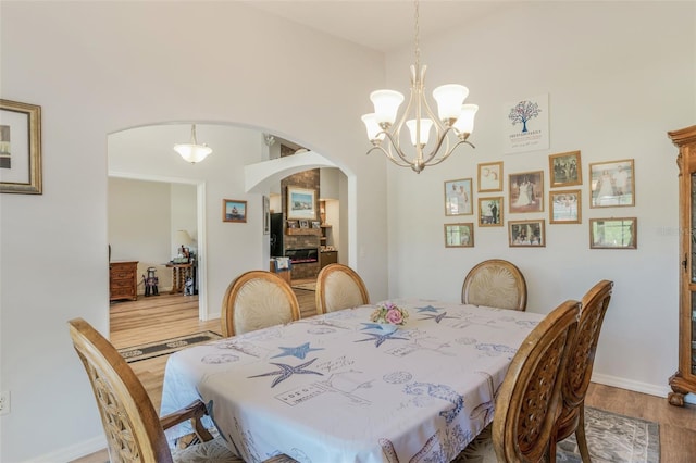 4277 E Bennett St, Inverness, FL 34453 - dining area featuring a chandelier, arched walkways, wood finished floors, and baseboards