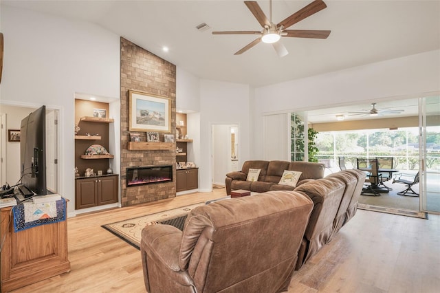 4277 E Bennett St, Inverness, FL 34453 - living area featuring visible vents, a brick fireplace, light wood-type flooring, a ceiling fan, and high vaulted ceiling