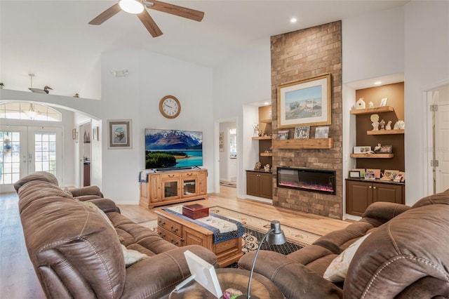 4277 E Bennett St, Inverness, FL 34453 - living room with high vaulted ceiling, built in shelves, a large fireplace, and a ceiling fan