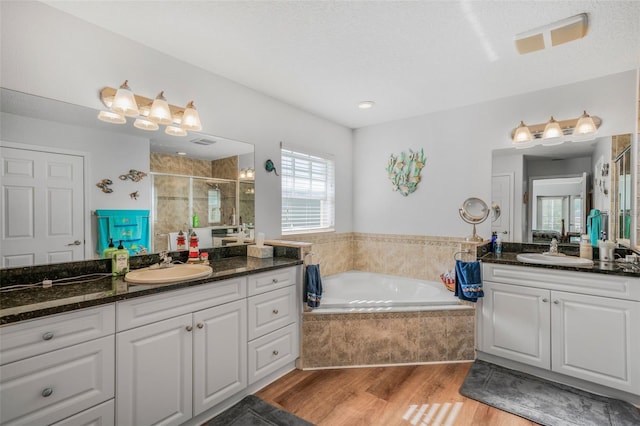 4277 E Bennett St, Inverness, FL 34453 - bathroom featuring two vanities, a sink, a stall shower, and wood finished floors
