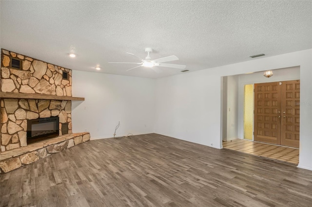 4401 E Windmill Dr, Inverness, FL 34453 - unfurnished living room with visible vents, a textured ceiling, a ceiling fan, and wood finished floors