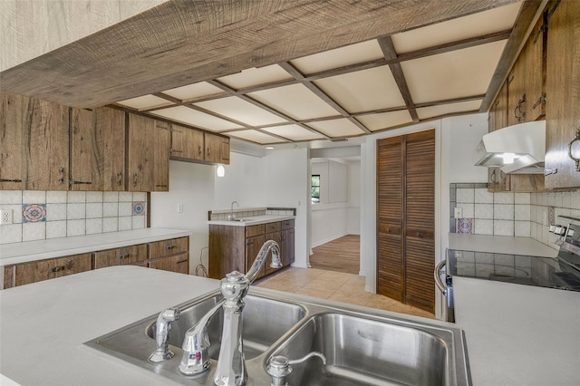 4401 E Windmill Dr, Inverness, FL 34453 - kitchen featuring brown cabinets, light countertops, tasteful backsplash, and under cabinet range hood