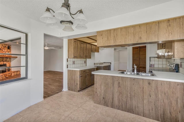 4401 E Windmill Dr, Inverness, FL 34453 - kitchen featuring brown cabinetry, a textured ceiling, tasteful backsplash, and a sink