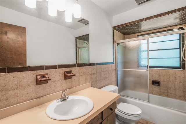 4401 E Windmill Dr, Inverness, FL 34453 - full bathroom featuring vanity, enclosed tub / shower combo, toilet, visible vents, and tile walls