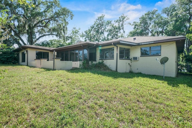 4401 E Windmill Dr, Inverness, FL 34453 - rear view of house with a sunroom, stucco siding, and a lawn