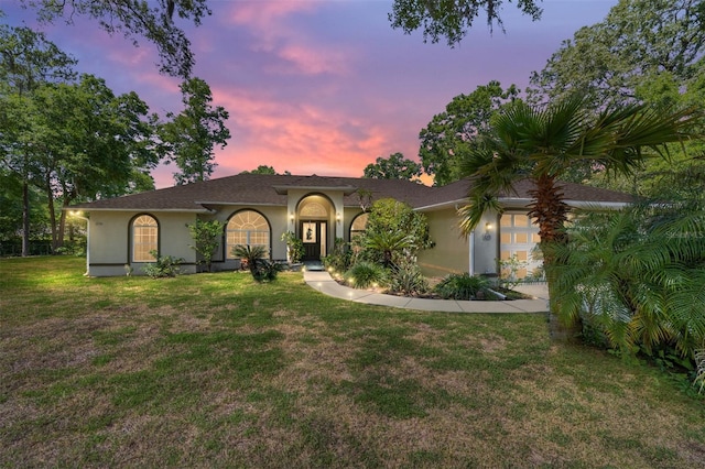 view of front facade with stucco siding and a front lawn