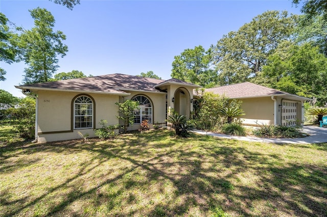 view of front of home featuring an attached garage, stucco siding, and a front lawn
