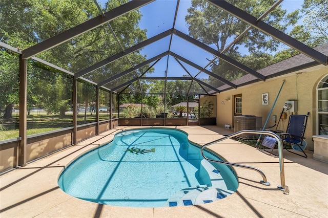 outdoor pool with a lanai, a patio area, and central AC