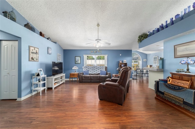 living room with ceiling fan, a textured ceiling, and wood finished floors