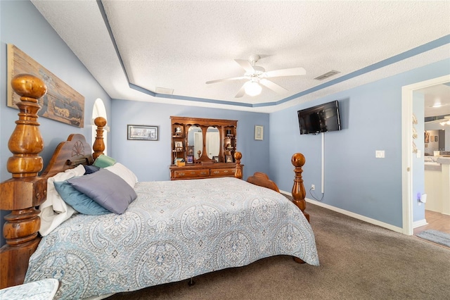 carpeted bedroom featuring visible vents, ceiling fan, baseboards, and a textured ceiling