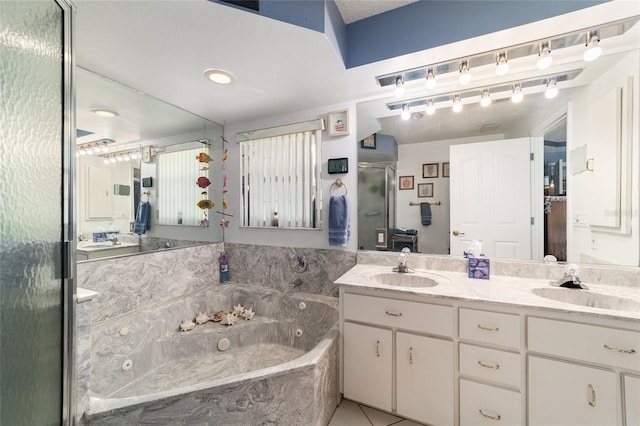 full bathroom featuring a shower stall, double vanity, a sink, and a tub with jets