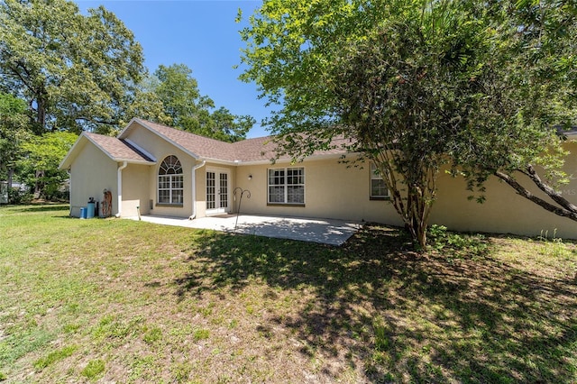 back of house with a yard, french doors, a patio, and stucco siding