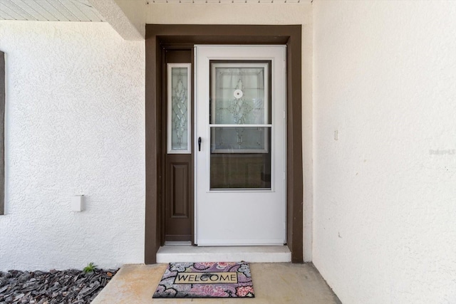 view of exterior entry with stucco siding