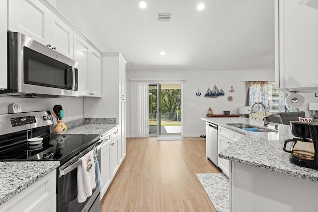 kitchen featuring stainless steel appliances, visible vents, a sink, light wood-type flooring, and white cabinetry