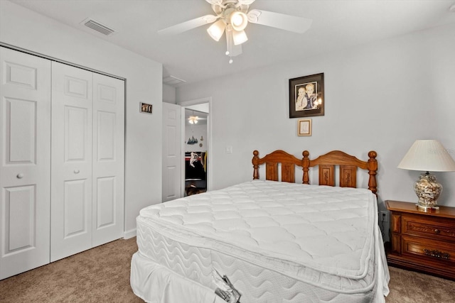 carpeted bedroom featuring a ceiling fan, visible vents, and a closet