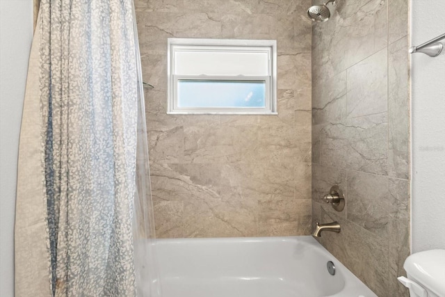 bathroom with toilet and shower / bath combination with curtain