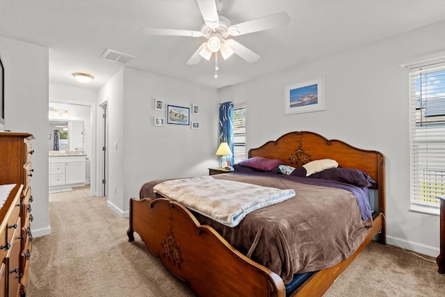 bedroom featuring connected bathroom, ceiling fan, light colored carpet, baseboards, and visible vents