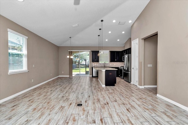 3918 NW 46th Ter, Ocala, FL 34482 - kitchen featuring light wood-type flooring, open floor plan, light countertops, freestanding refrigerator, and lofted ceiling