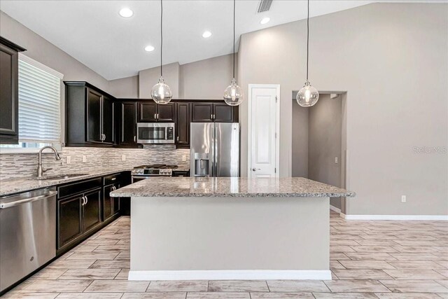 3918 NW 46th Ter, Ocala, FL 34482 - kitchen with a sink, tasteful backsplash, a center island, vaulted ceiling, and appliances with stainless steel finishes