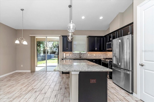 3918 NW 46th Ter, Ocala, FL 34482 - kitchen featuring tasteful backsplash, a sink, appliances with stainless steel finishes, a kitchen island, and wood finish floors