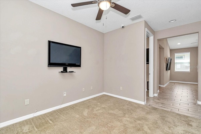 3918 NW 46th Ter, Ocala, FL 34482 - unfurnished living room featuring a textured ceiling, visible vents, baseboards, carpet floors, and a ceiling fan