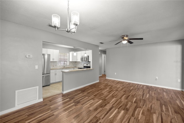 15044 SW 35th Avenue Rd, Ocala, FL 34473 - unfurnished living room featuring wood finished floors, ceiling fan with notable chandelier, a sink, and visible vents