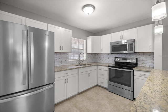 15044 SW 35th Avenue Rd, Ocala, FL 34473 - kitchen featuring light stone counters, backsplash, a sink, appliances with stainless steel finishes, and white cabinetry