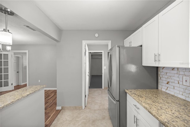 15044 SW 35th Avenue Rd, Ocala, FL 34473 - kitchen featuring light stone countertops, visible vents, white cabinetry, and freestanding refrigerator