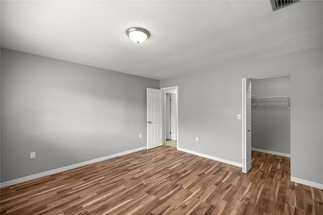 15044 SW 35th Avenue Rd, Ocala, FL 34473 - unfurnished bedroom with a closet, baseboards, a textured ceiling, visible vents, and wood finished floors
