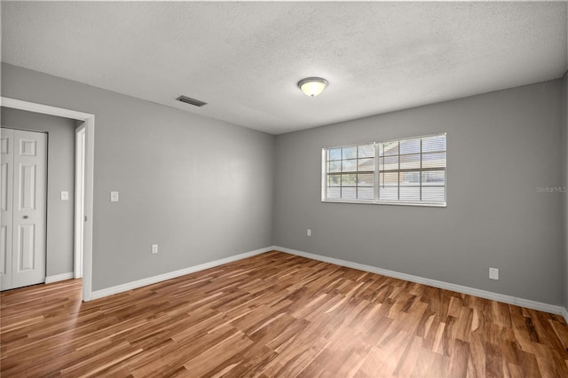 15044 SW 35th Avenue Rd, Ocala, FL 34473 - empty room featuring baseboards, wood finished floors, a textured ceiling, and visible vents