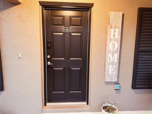 entrance to property with stucco siding