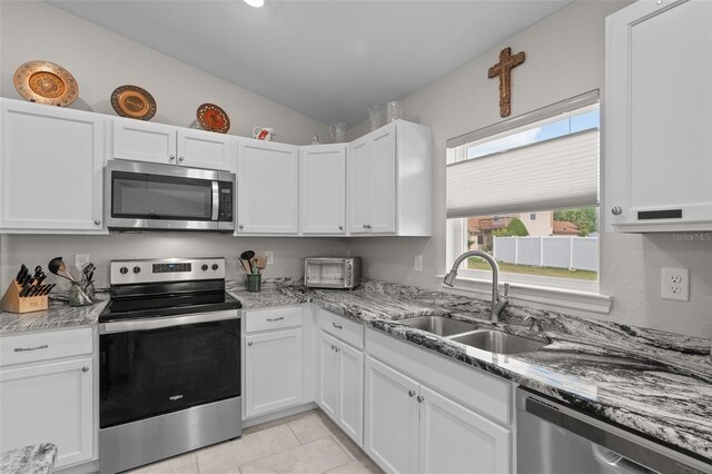 7886 SW 103rd Loop, Ocala, FL 34476 - kitchen with light stone counters, appliances with stainless steel finishes, white cabinets, a sink, and lofted ceiling