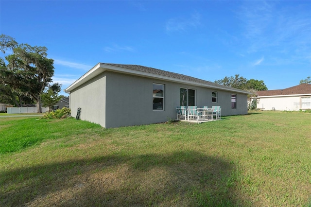 7886 SW 103rd Loop, Ocala, FL 34476 - rear view of property with stucco siding and a yard