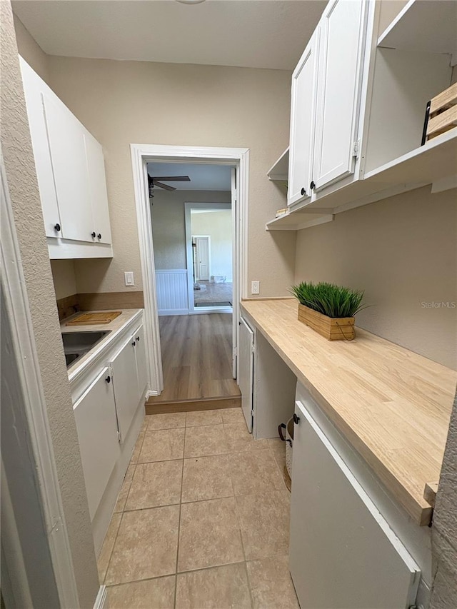 interior space featuring white cabinetry, light countertops, a sink, and open shelves