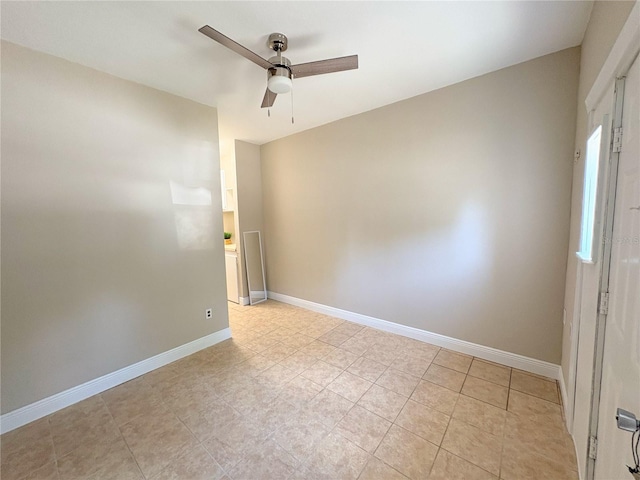 spare room featuring light tile patterned floors, baseboards, and a ceiling fan