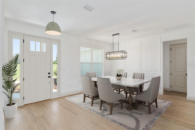 1784 NW 85th Loop, Ocala, FL 34475 - dining room featuring healthy amount of natural light, light wood finished floors, a chandelier, and a decorative wall