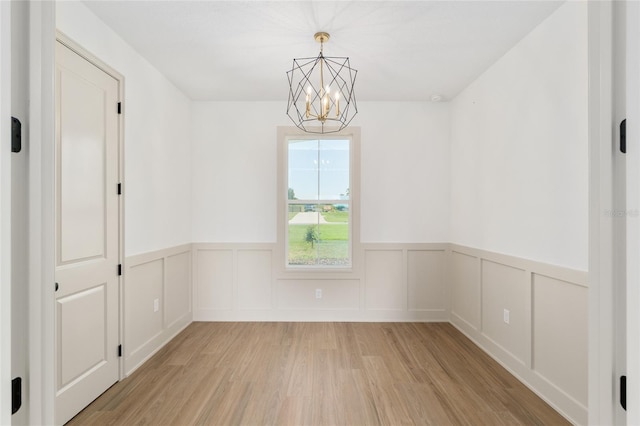1784 NW 85th Loop, Ocala, FL 34475 - empty room featuring a chandelier, light wood-style floors, and wainscoting