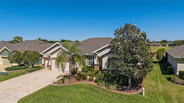 view of front facade with stucco siding, driveway, a front yard, and a garage