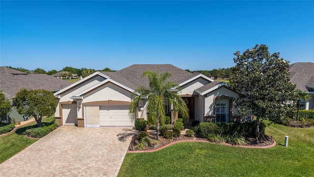 ranch-style house featuring stucco siding, driveway, a front yard, and a garage