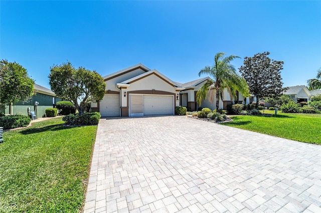 ranch-style home with stucco siding, an attached garage, a front yard, and decorative driveway