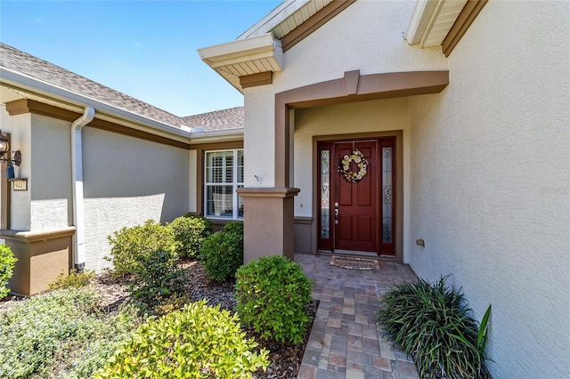 view of exterior entry featuring stucco siding
