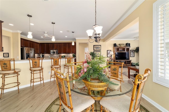 dining room with crown molding, ceiling fan with notable chandelier, light wood-type flooring, baseboards, and recessed lighting