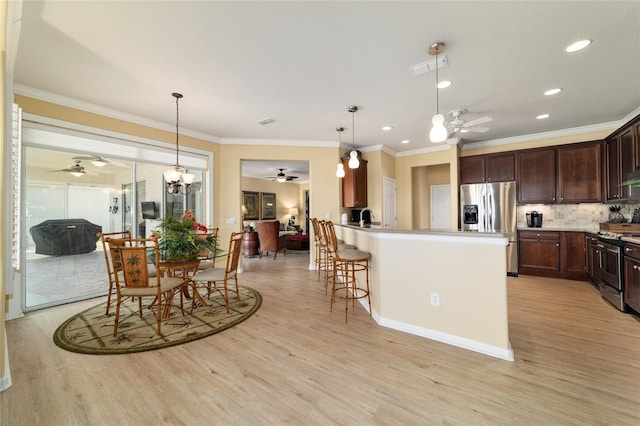 kitchen with light wood-type flooring, appliances with stainless steel finishes, and a ceiling fan