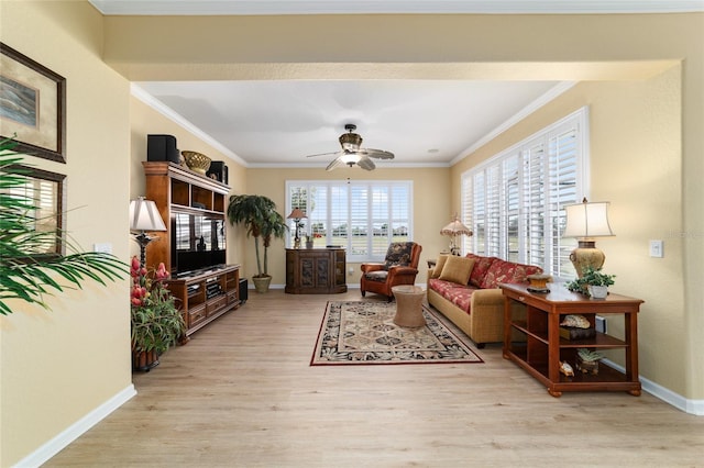 living area with ceiling fan, baseboards, crown molding, and light wood finished floors