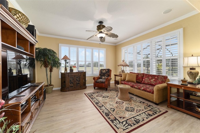 living room with light wood-type flooring, crown molding, baseboards, and ceiling fan
