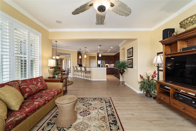 living area with ornamental molding, light wood finished floors, baseboards, and ceiling fan