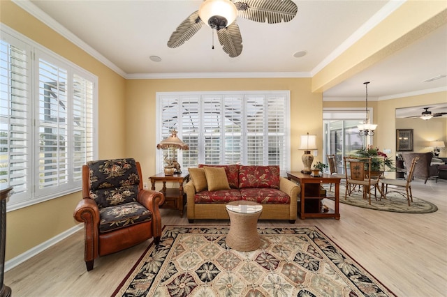 living area featuring ceiling fan, baseboards, ornamental molding, and wood finished floors