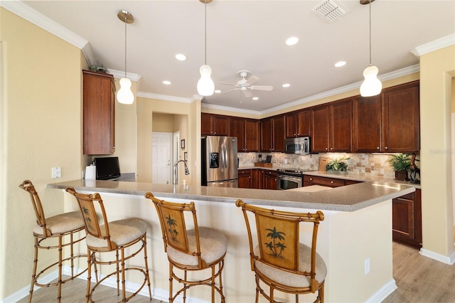 kitchen featuring a ceiling fan, tasteful backsplash, stainless steel appliances, a peninsula, and visible vents
